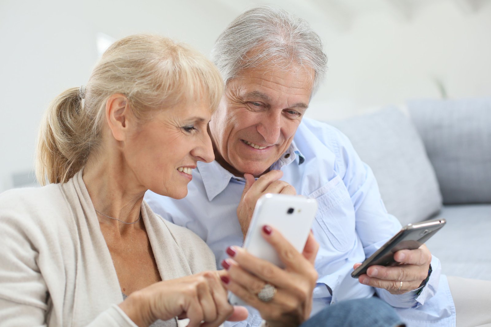 Senior couple at home using smartphone Senior couple at home using smartphone
